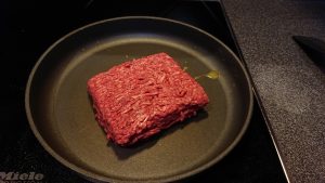 A «brick» of minced meat in a frying pan.